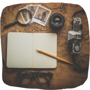 Weltkarte mit Lupe, Notizbuch und Kamera