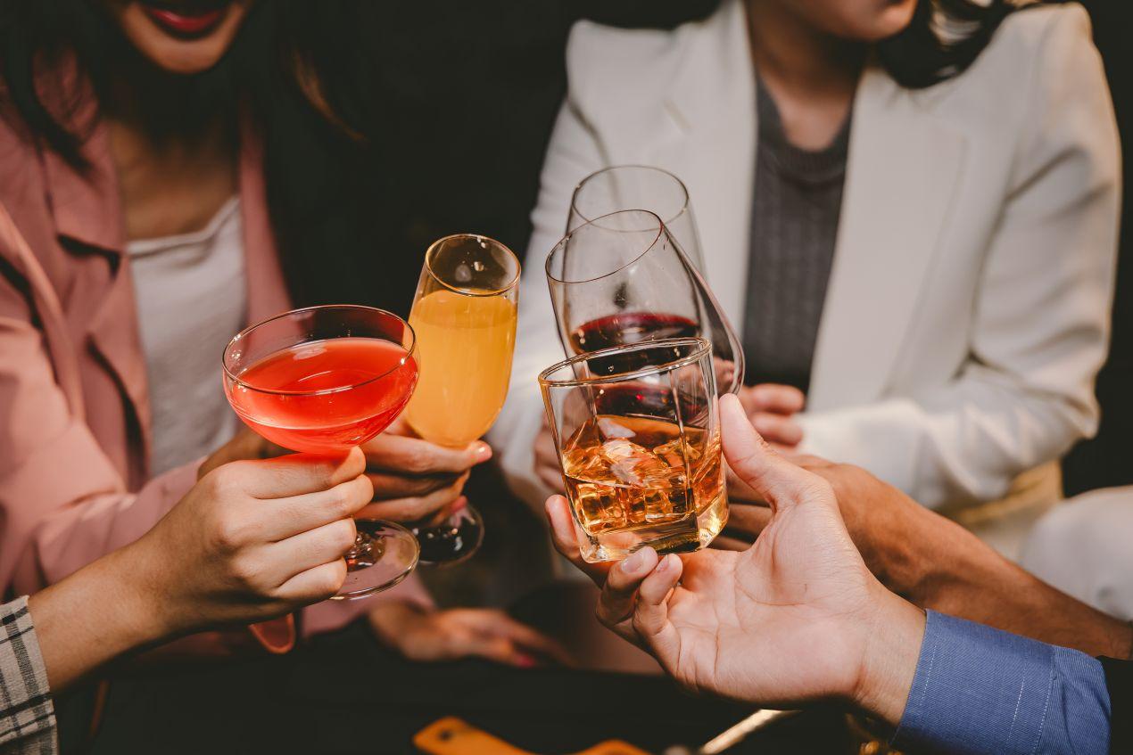 Menschen stossen mit Cocktails und Wein an – stimmungsvolle Firmenevent Location mit stilvoller Bar für Teamevents und Get-together