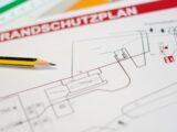 Brandschutzplan mit Bleistift und Markierungen auf Tisch | Brandwache Berlin