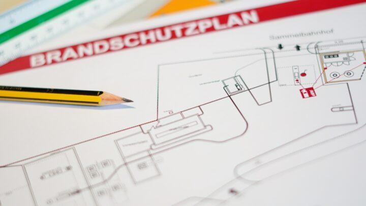 Brandschutzplan mit Bleistift und Markierungen auf Tisch | Brandwache Berlin